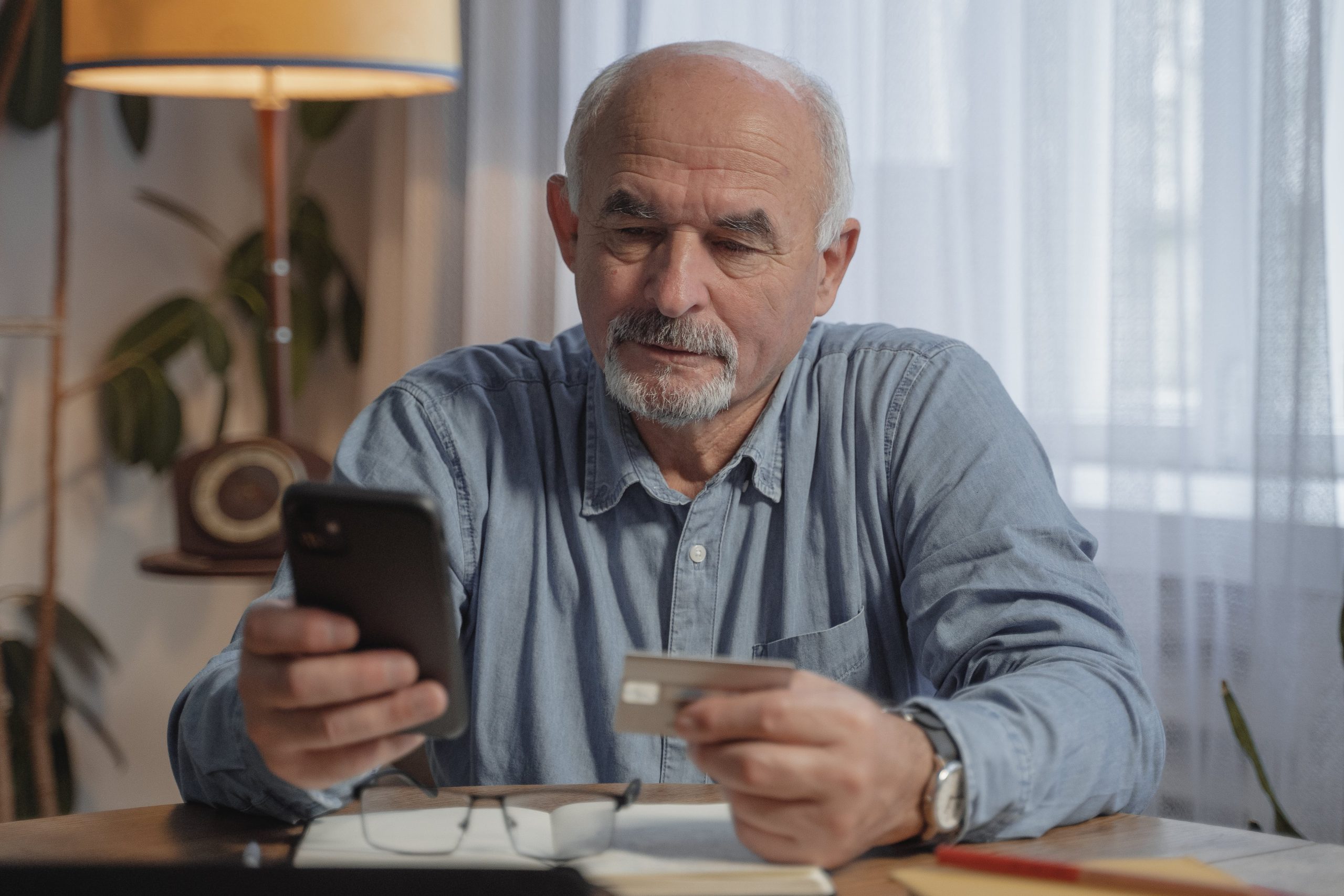 old man donor giving on phone with credit card